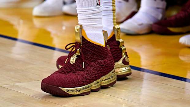 View of maroon and gold Nike LeBron shoes.